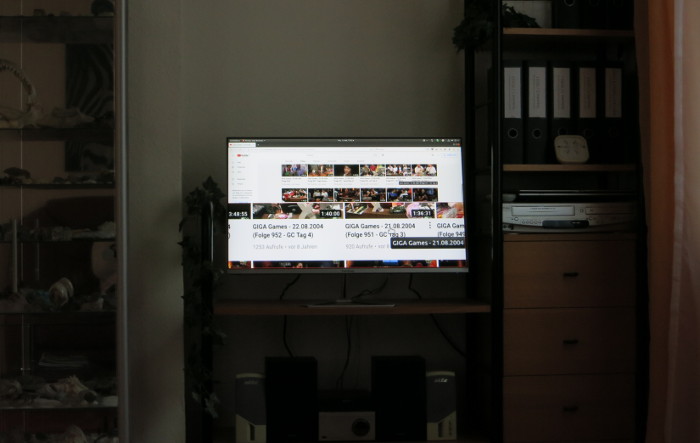 Monitor zwischen Wandregalen, der in der unteren Hälfte ein vergrößertes Bild anzeigt.
