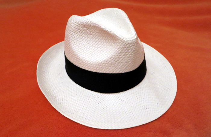 Weißer Hut mit breiter Krempe und schwarzem Band.