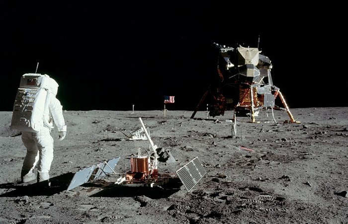 Buzz Aldrin im Raumanzug auf dem Mond. Raumkapsel im Hintergrund.