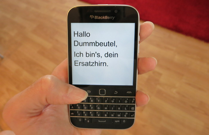 Smartphone zeigt Text: Hallo Dummbeutel, Ich bin's, dein Ersatzhirn.