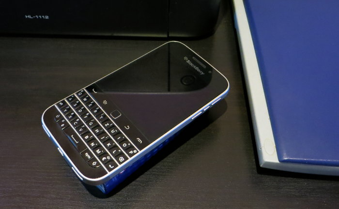 Smartphone liegt um 45 Grad verdreht neben rechtwinkelig stehendem Drucker und Scanner.