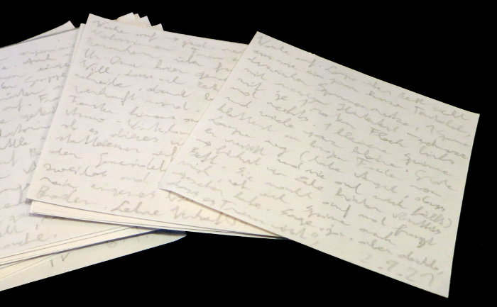 Einige kleine, quadratische Zettel, die mit Bleistift beschriftet sind.