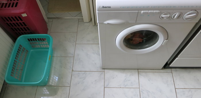 Zwischen Waschmaschine und Wäschekorb bleibt nur ein schmaler Durchgang.